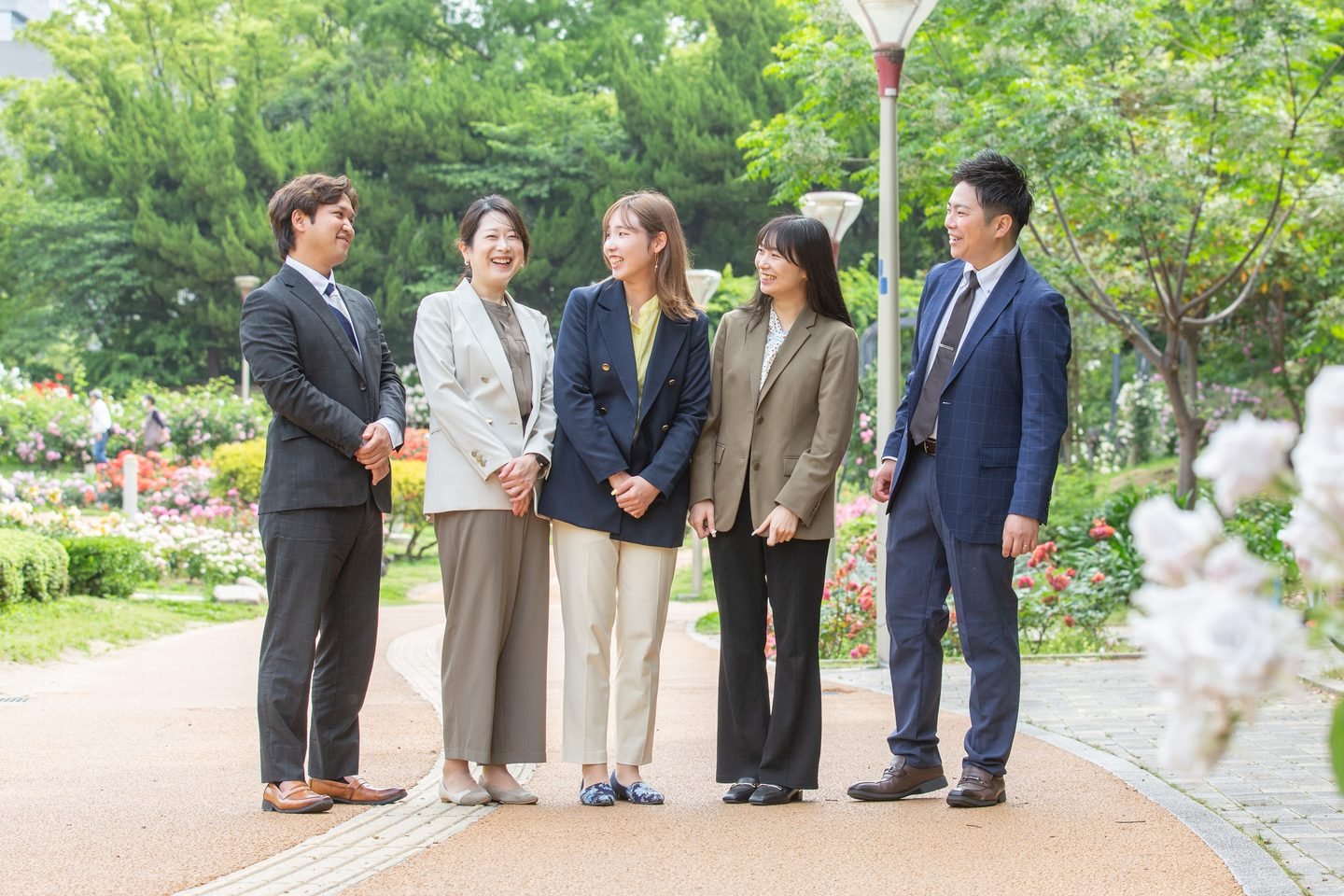 スパークルキャリアのチームメンバーが緑の中で笑顔で語り合うシーン